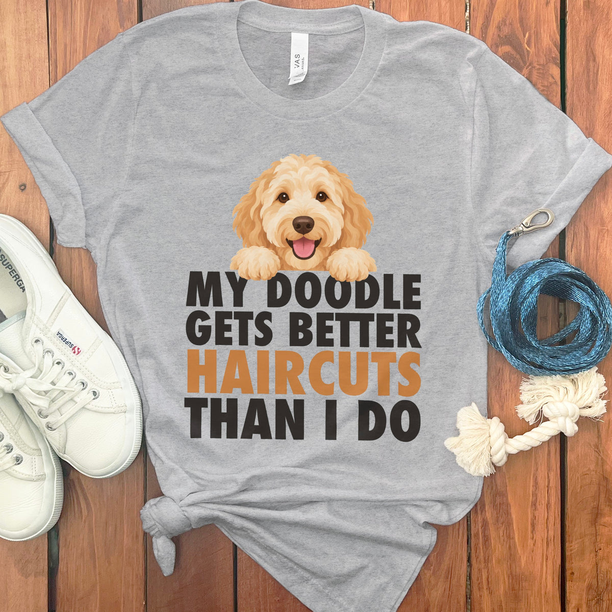 Grey t-shirt with cartoon doodle and text "MY DOODLE GETS BETTER HAIRCUTS THAN I DO".