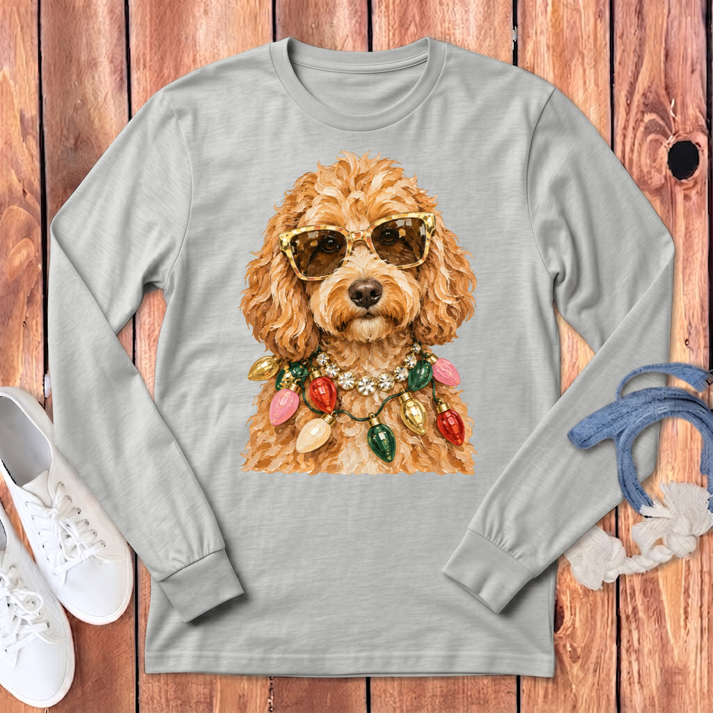 Dog wearing sunglasses and festive Christmas lights necklace on light gray long-sleeve shirt.