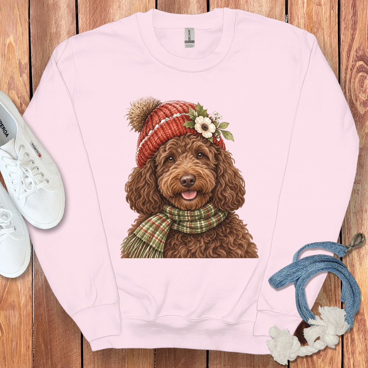 Pink sweatshirt with watercolor doodle wearing a red hat and green plaid scarf.