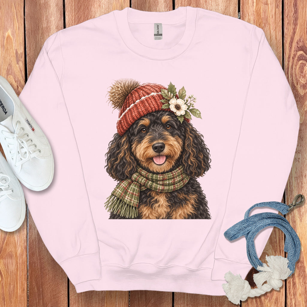Pink sweatshirt with a watercolor illustration of a dog wearing a beanie and scarf.