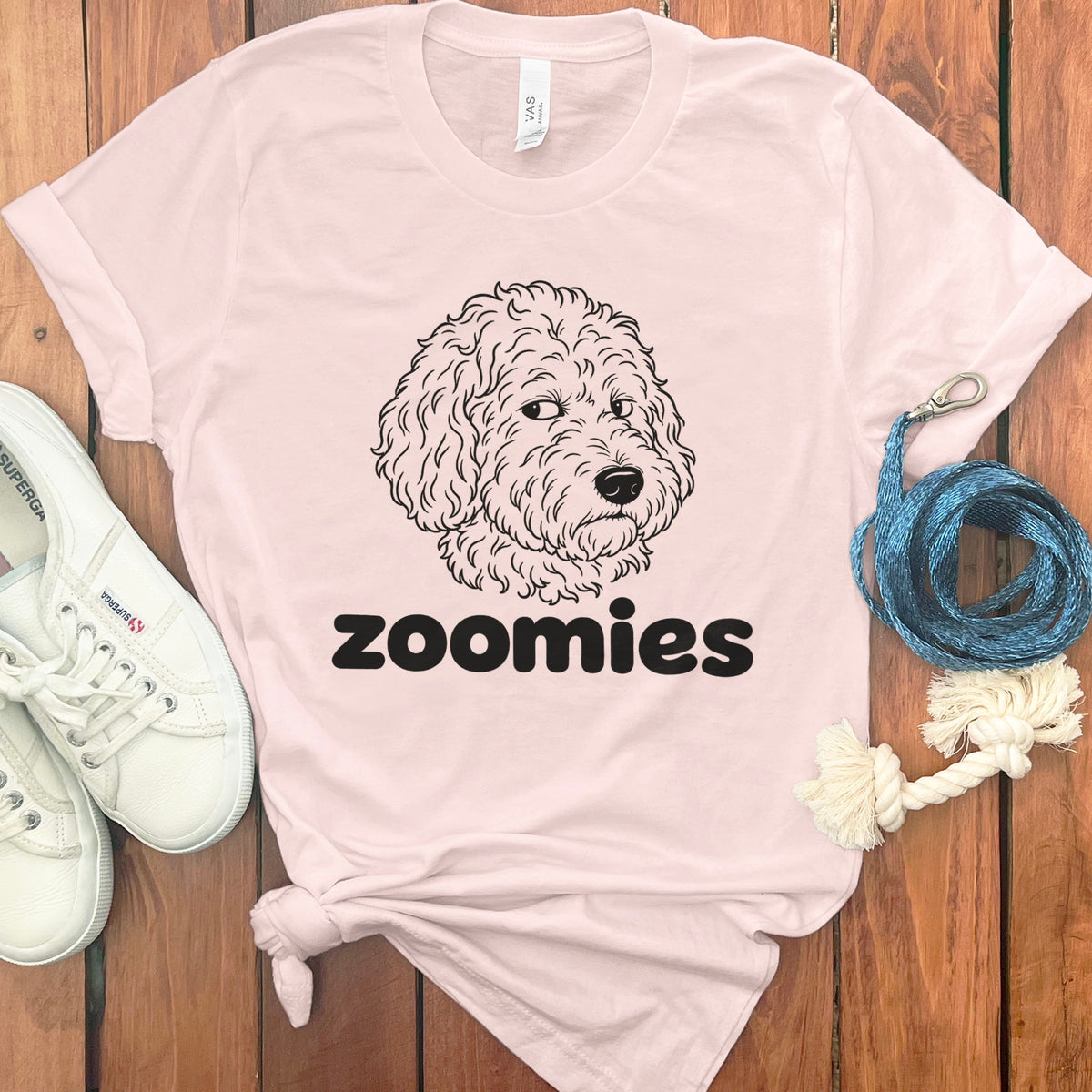 Pink t-shirt with black doodle dog face and "zoomies" text.