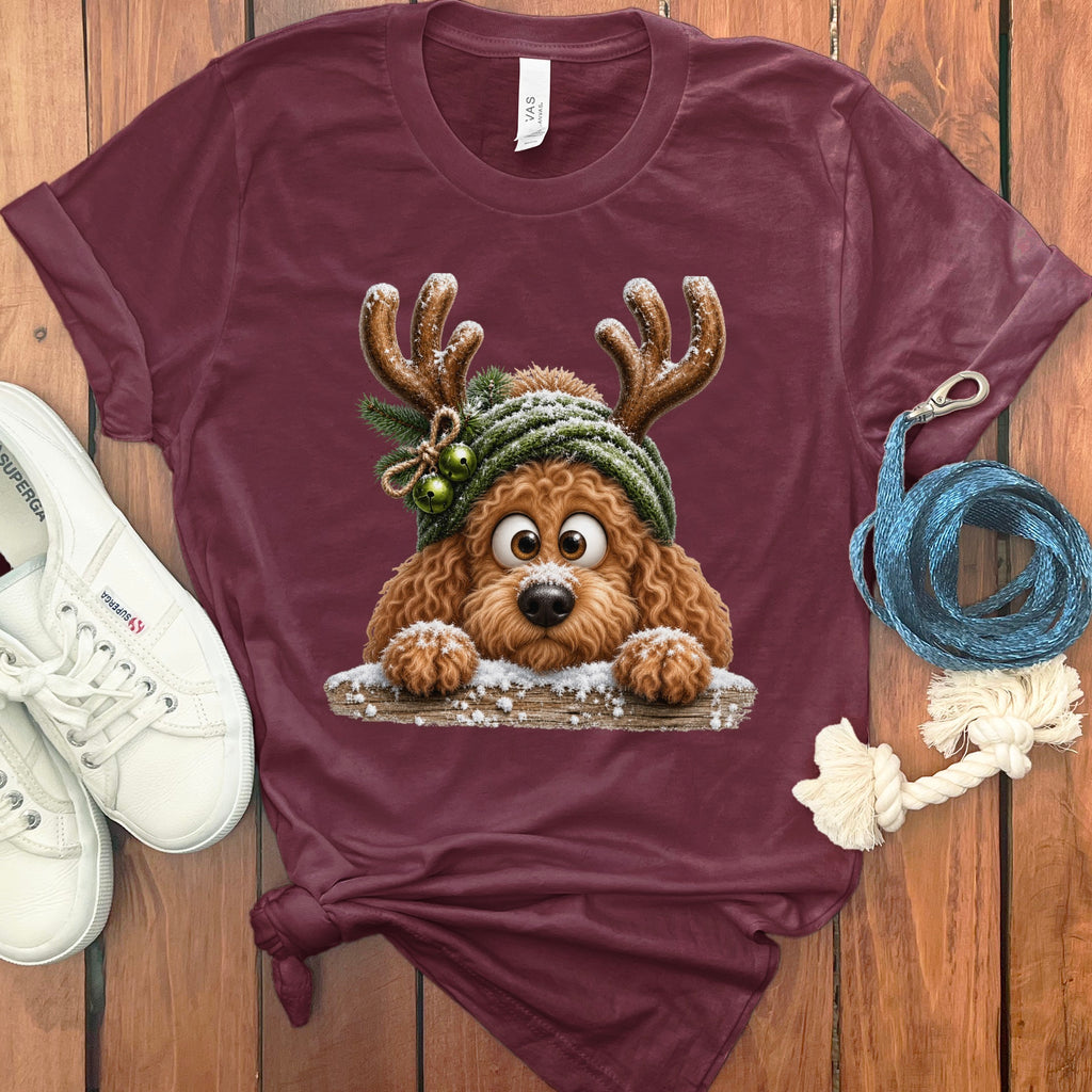 Maroon t-shirt with a cartoon dog wearing reindeer antlers and a green hat.