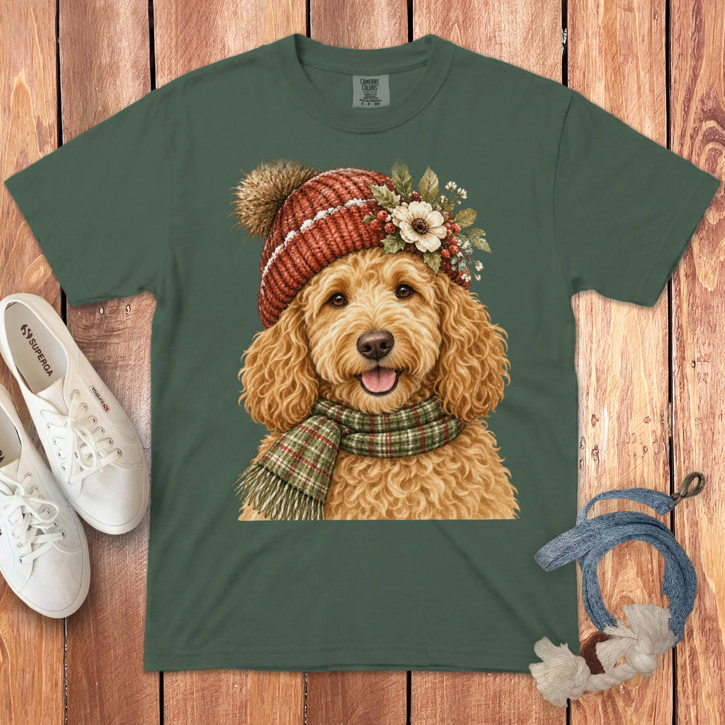 Green t-shirt with a festive goldendoodle wearing a red knit hat and plaid scarf.
