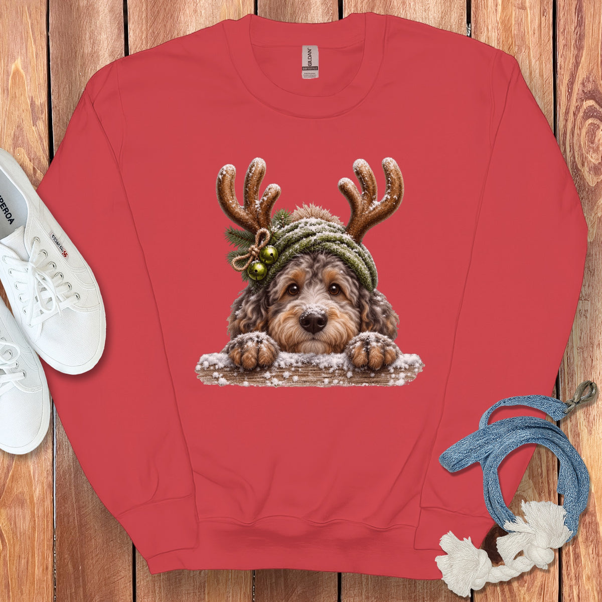 Red sweatshirt with a printed design of a fluffy dog wearing reindeer antlers and a hat.