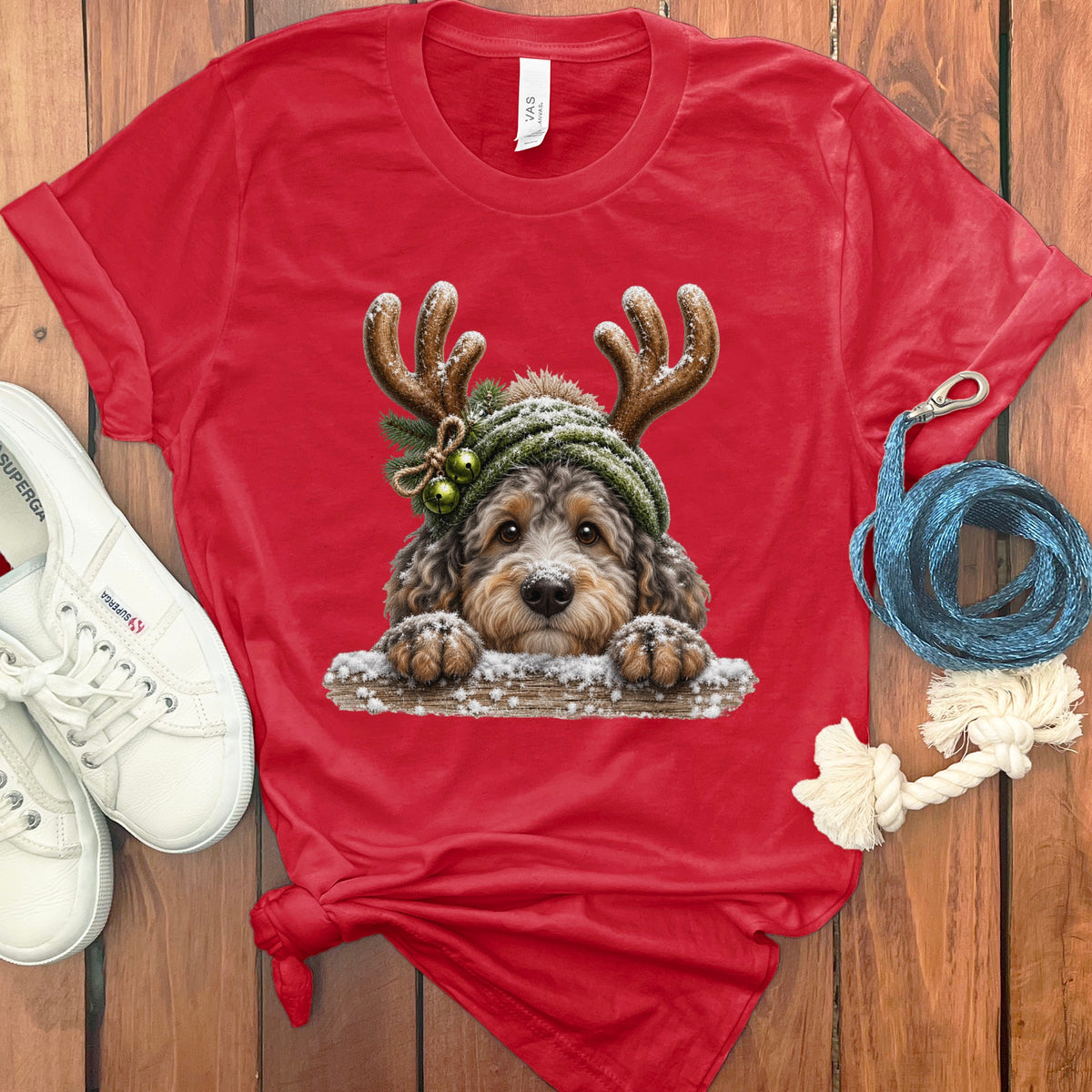 Red t-shirt with a festive doodle dog wearing reindeer antlers and a beanie.