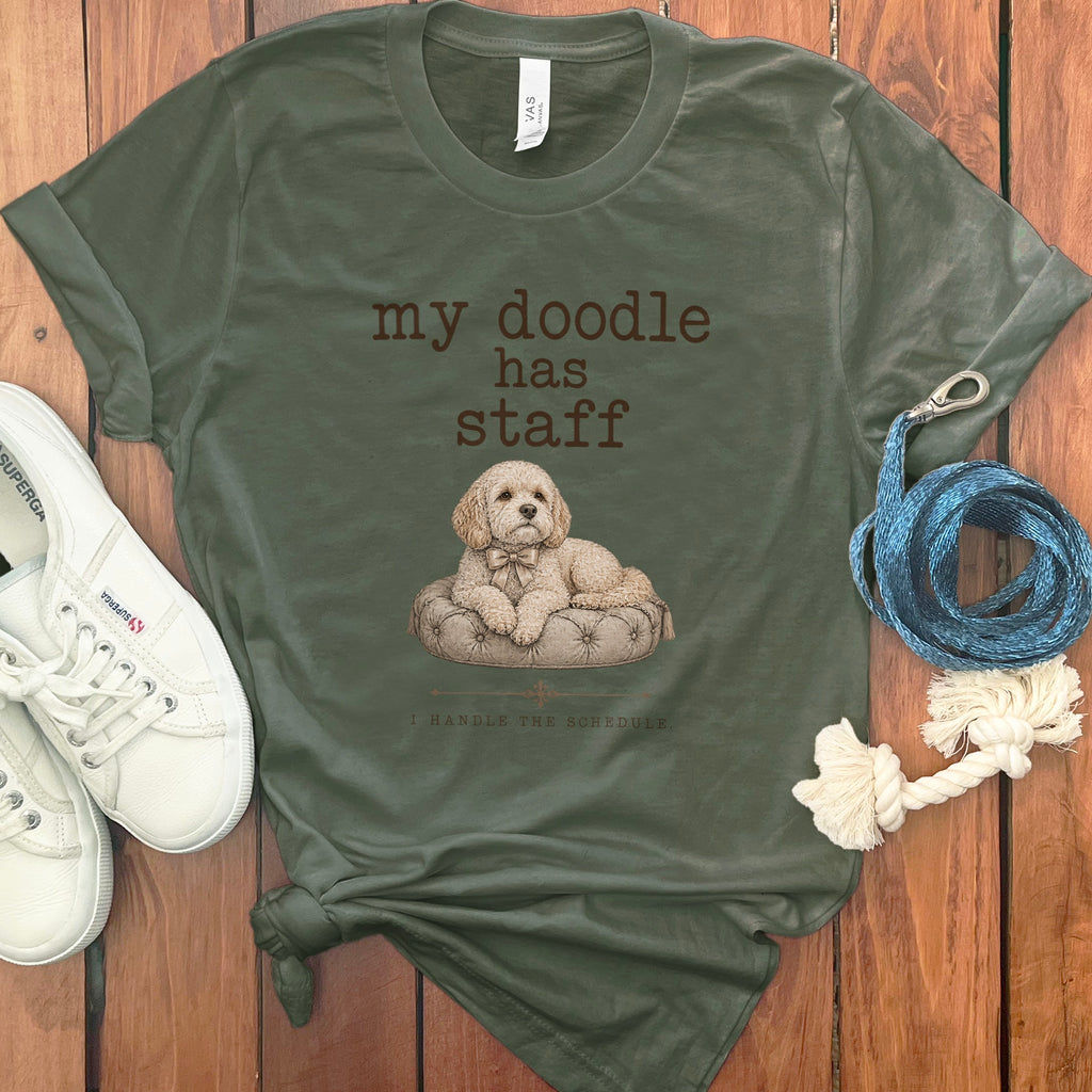 Olive green t-shirt with a doodle graphic and text "my doodle has staff. I HANDLE THE SCHEDULE."
