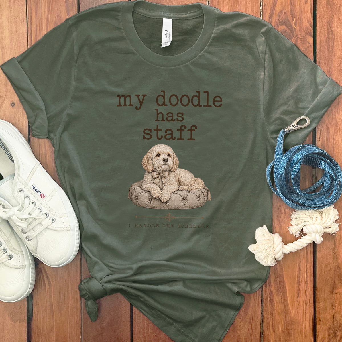 Olive green t-shirt with a doodle graphic and text "my doodle has staff. I HANDLE THE SCHEDULE."