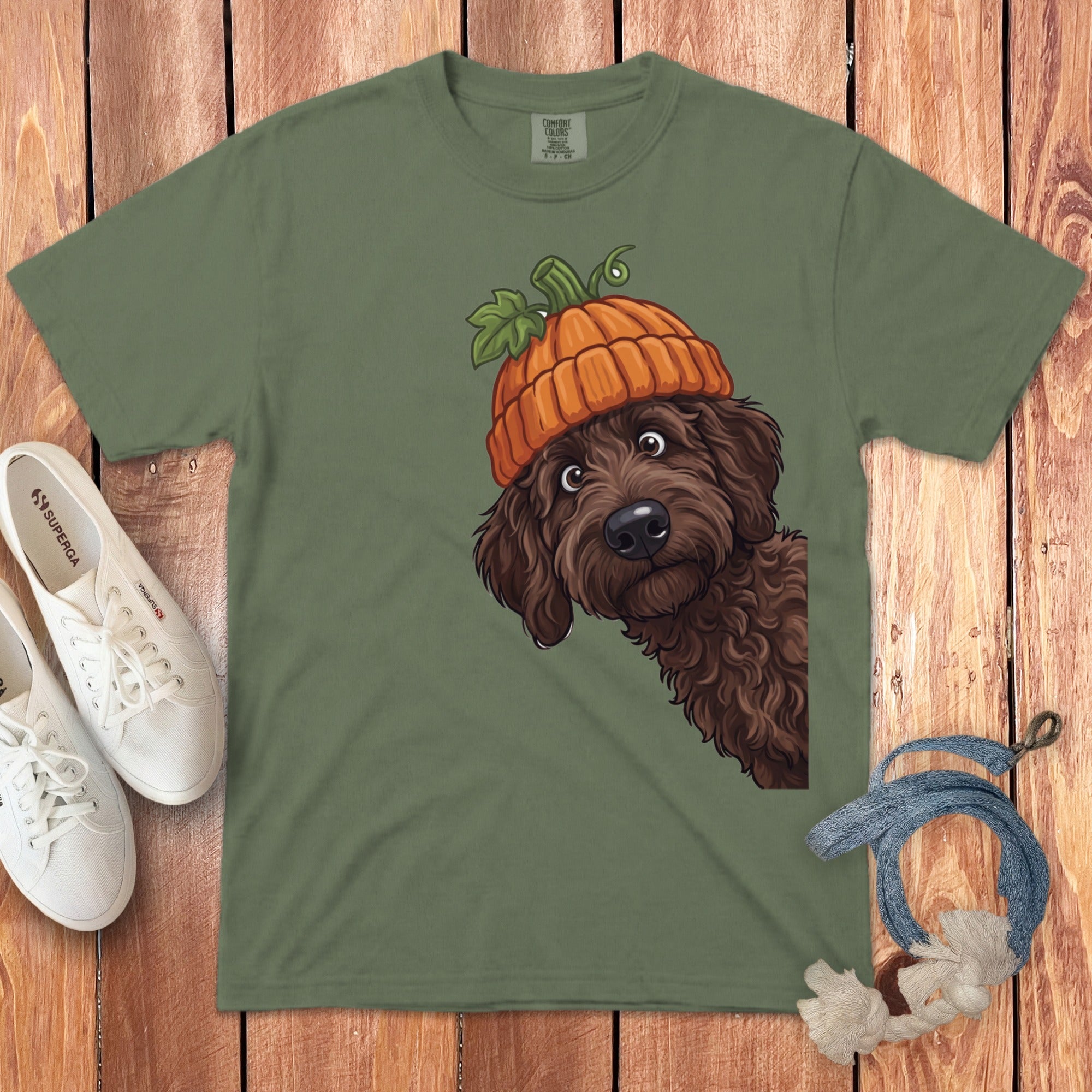Green t-shirt with illustration of a brown dog wearing a pumpkin hat.