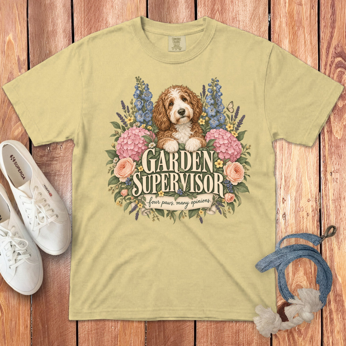 A pale yellow t-shirt features a doodle dog graphic surrounded by flowers and the text Garden Supervisor.