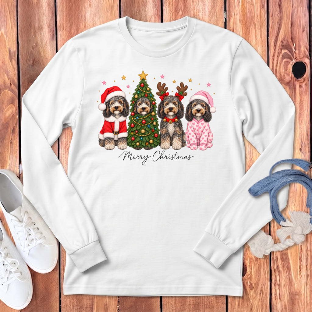 A white long-sleeved shirt features a graphic of four doodle dogs in Christmas attire surrounding a decorated tree, with the text Merry Christmas below.