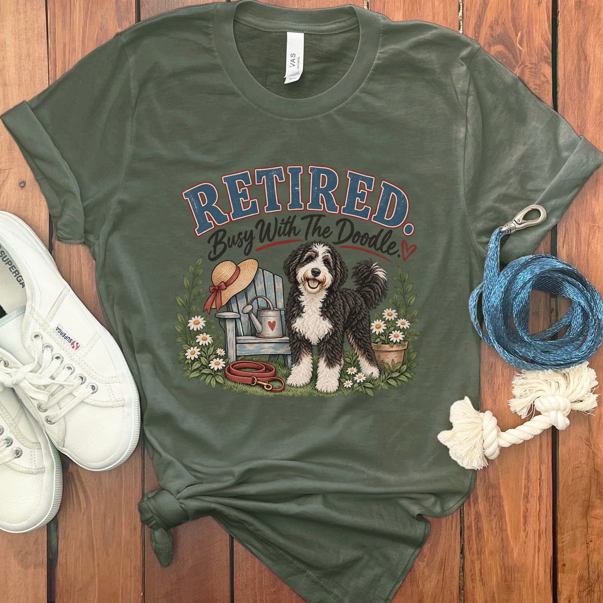 Green t-shirt with "RETIRED. Busy With The Doodle." text and a dog illustration.