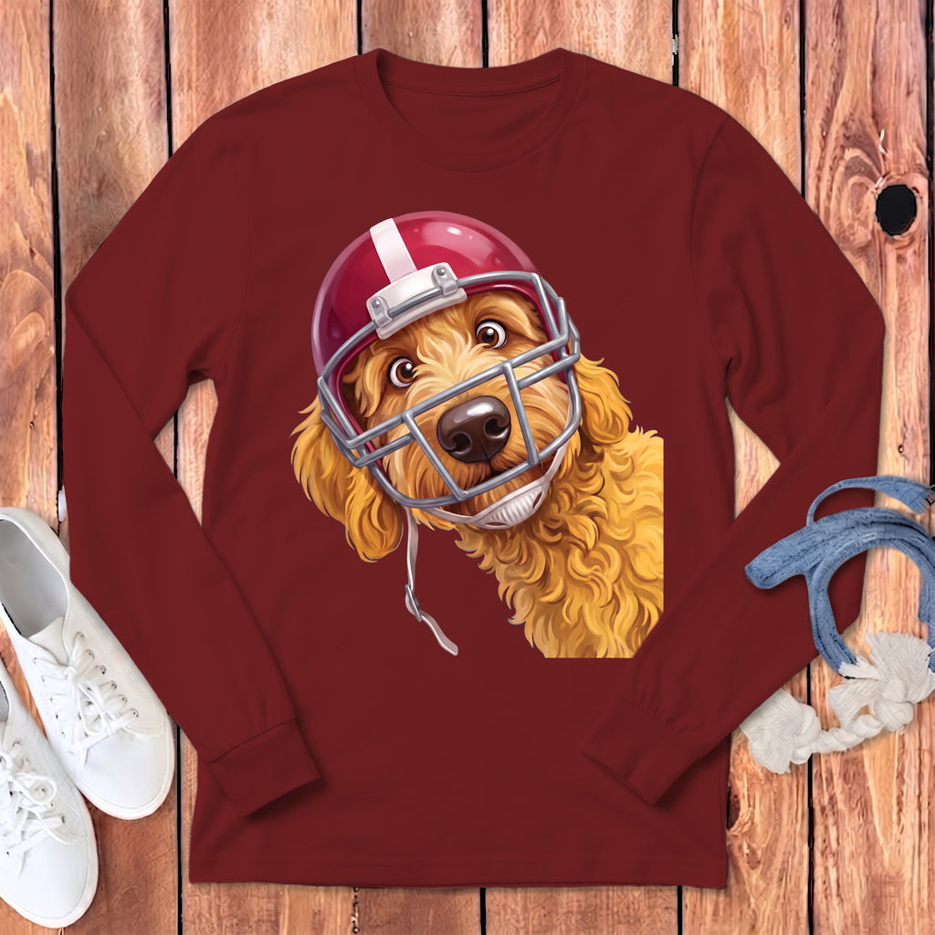 Golden doodle dog wearing a red football helmet on a maroon long-sleeve shirt.