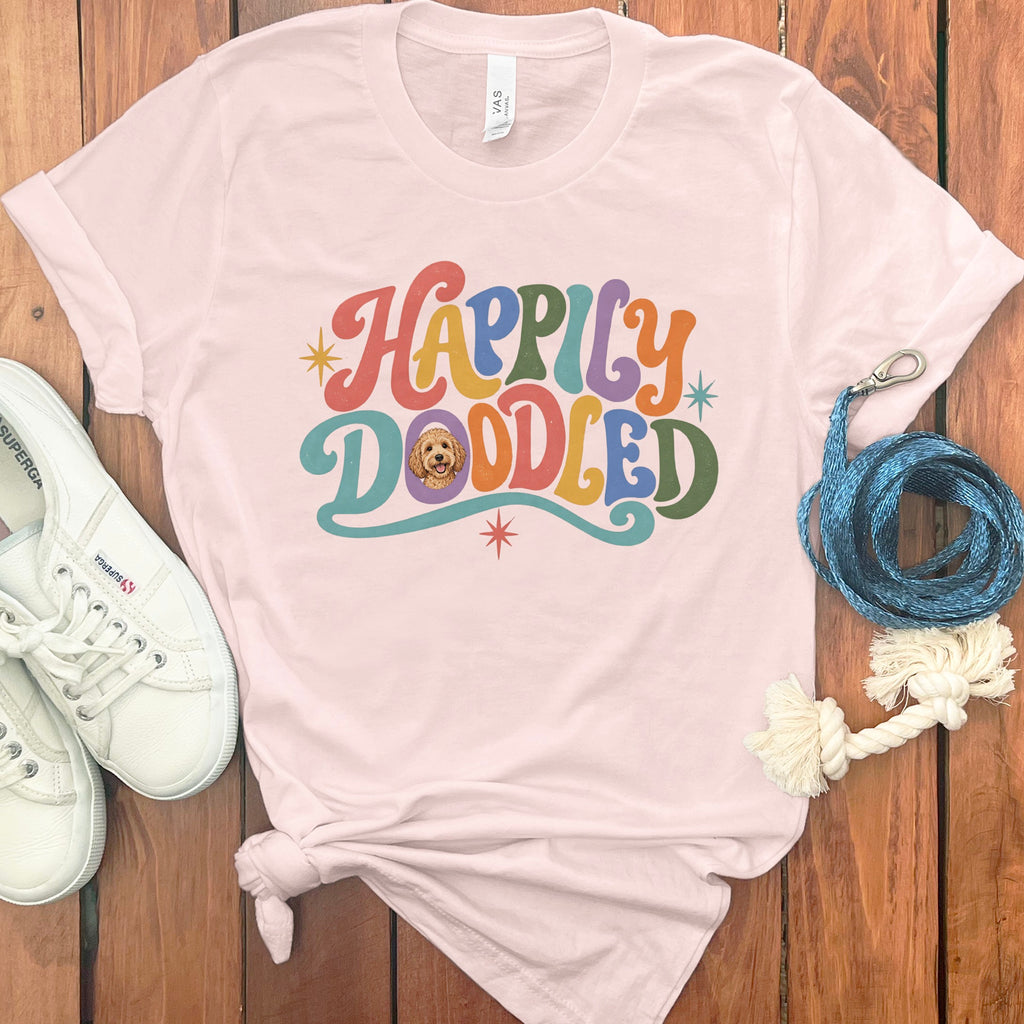 Pink t-shirt with "Happily Doodled" text and a dog illustration.