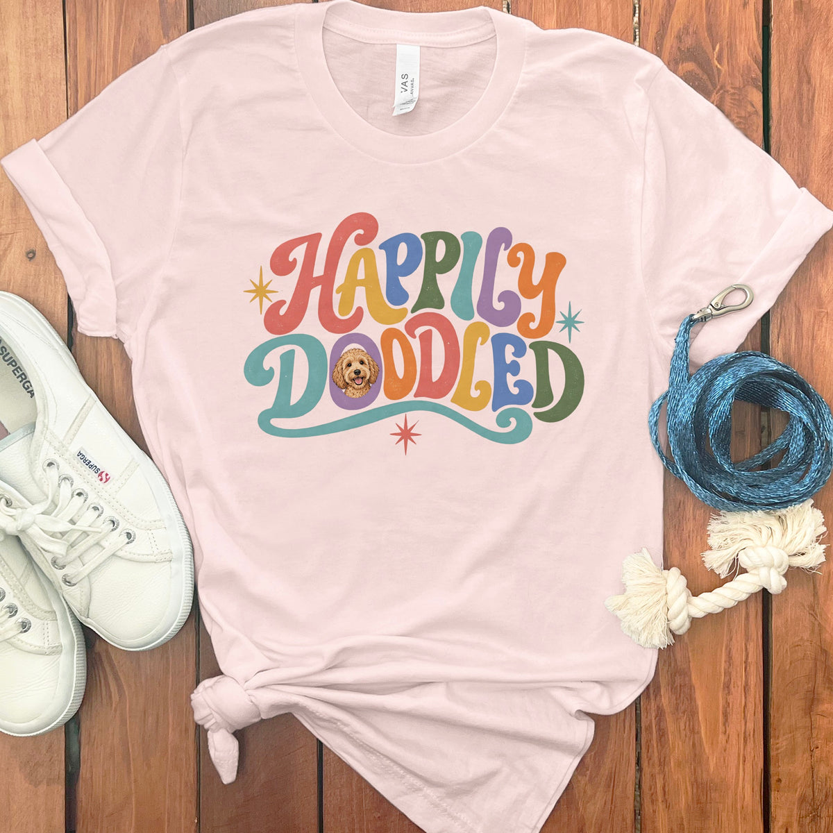 Pink t-shirt with "Happily Doodled" text and a dog illustration.