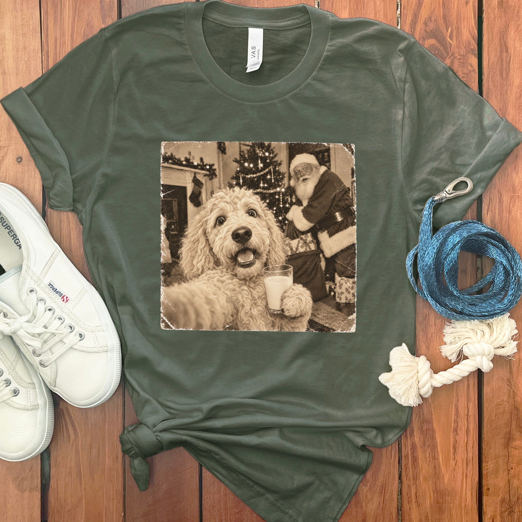 A dark green t-shirt featuring a vintage graphic of a fluffy dog holding a glass of milk with Santa Claus in the background.