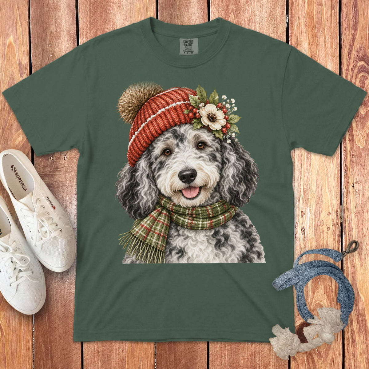 Green t-shirt with a doodle dog wearing a red beanie and plaid scarf.