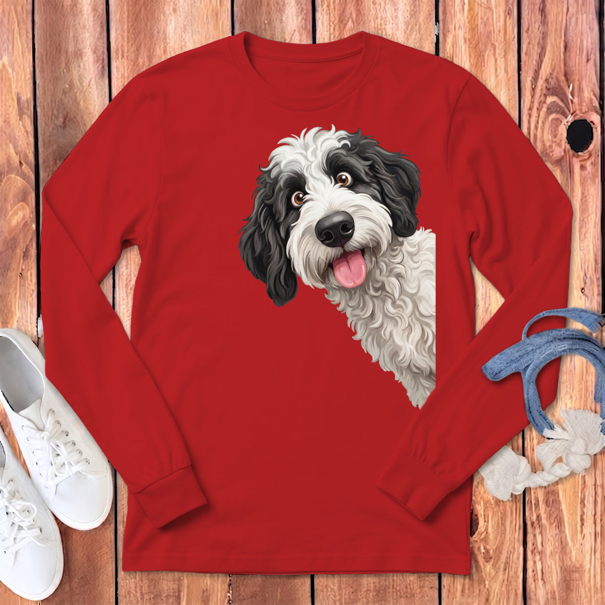 Black and white dog artwork on a red long-sleeve shirt with sneakers and denim.