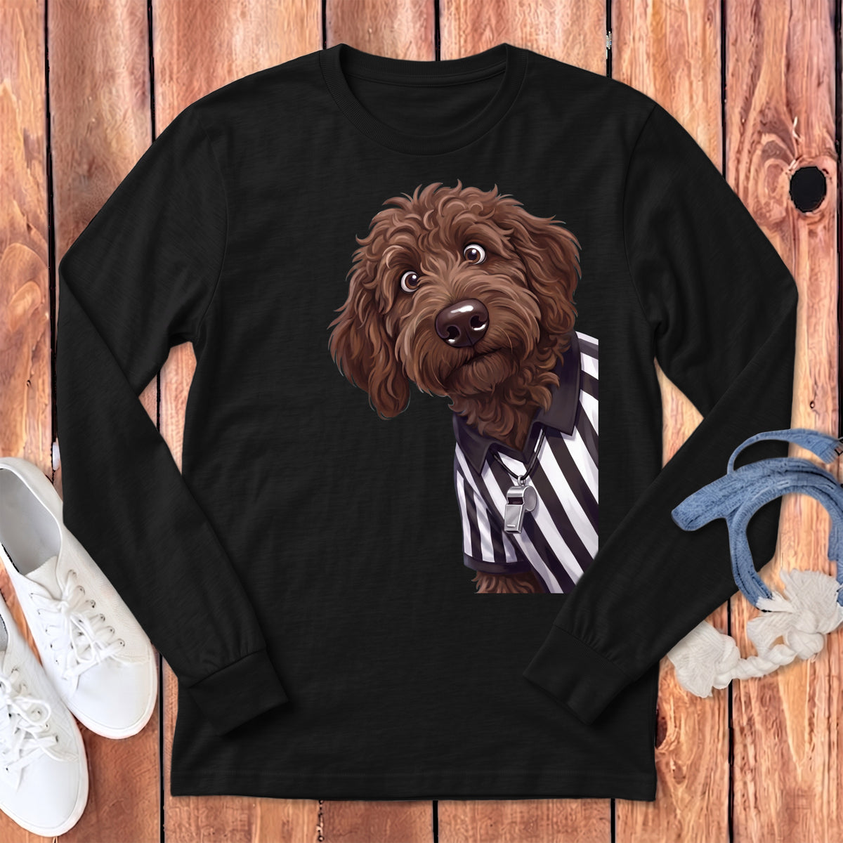 Brown doodle dog wearing a referee shirt with a whistle on a black long-sleeved shirt.
