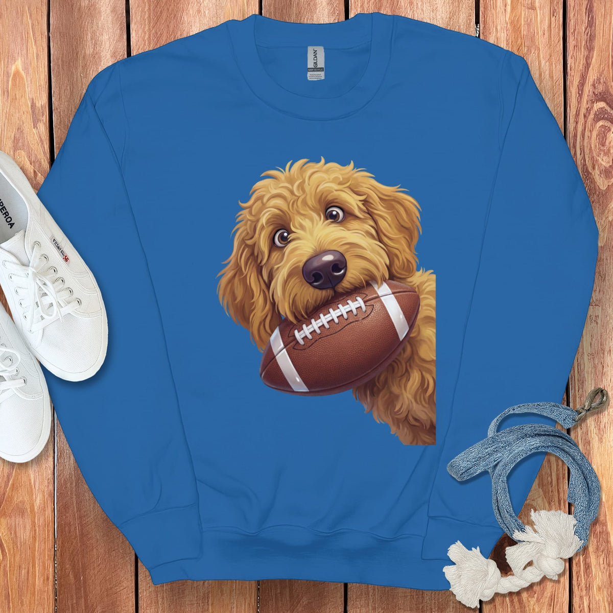 Blue sweatshirt with a golden doodle dog holding a football.