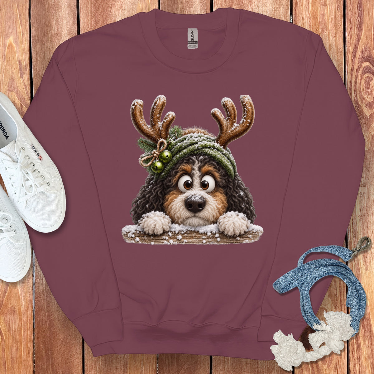 Burgundy sweatshirt with a cartoon dog wearing reindeer antlers and a hat.