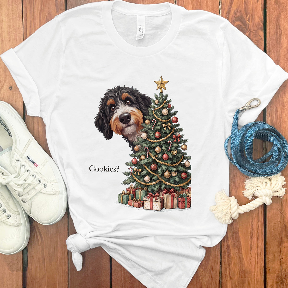 White t-shirt with dog peeking from behind a Christmas tree, text "Cookies?".