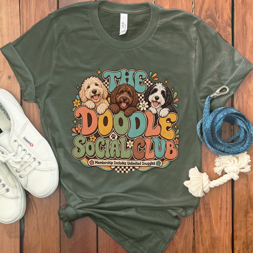 Green t-shirt with "The Doodle Social Club" graphic featuring three doodle dogs and flowers.