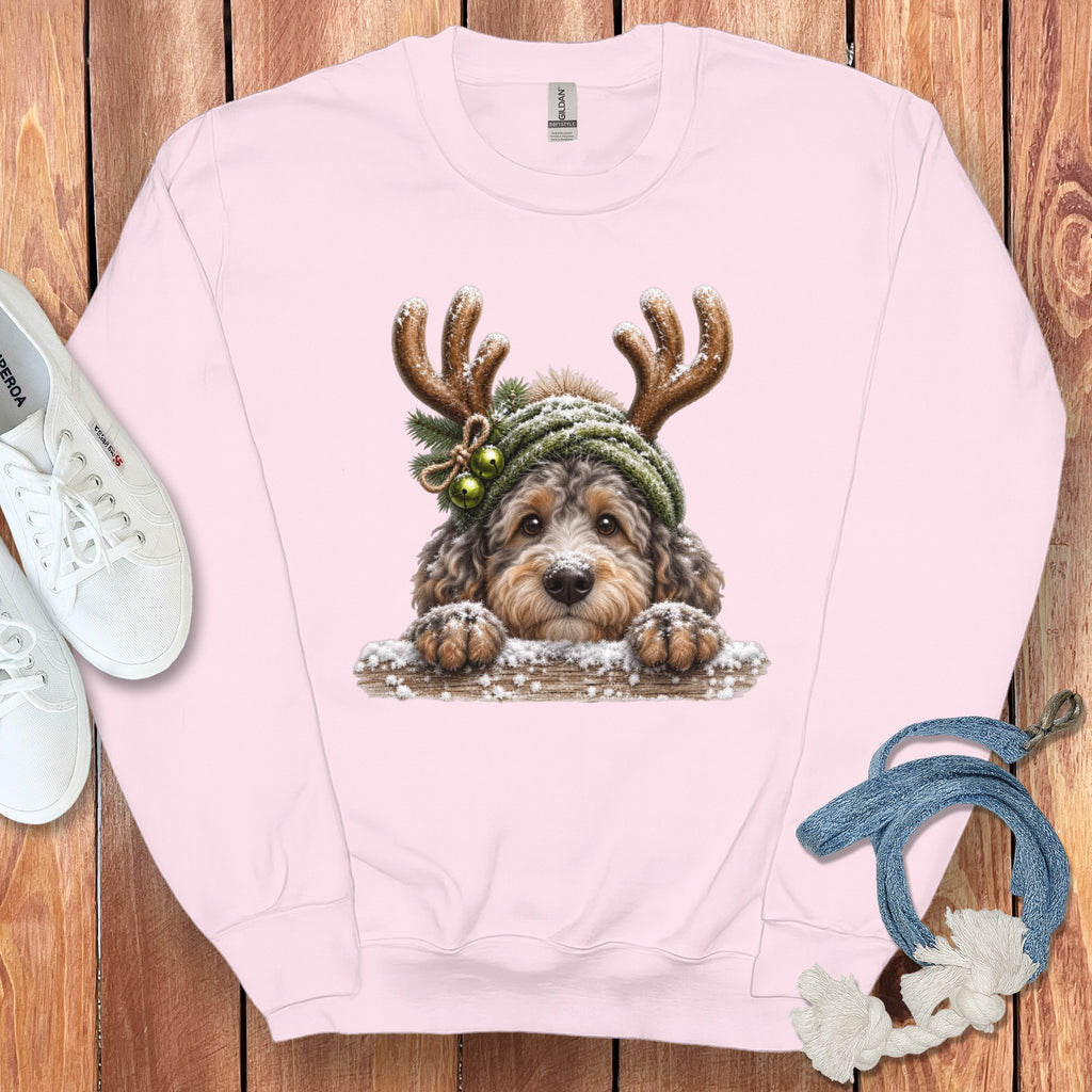 Pink sweatshirt with a Christmas doodle dog wearing antlers and a green hat.