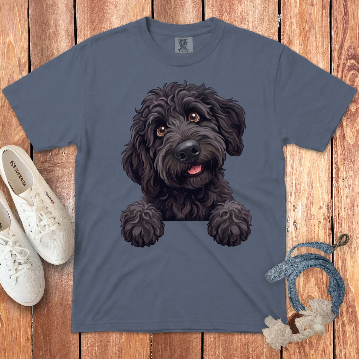 Black doodle dog peeking over a pocket on a grey t-shirt.