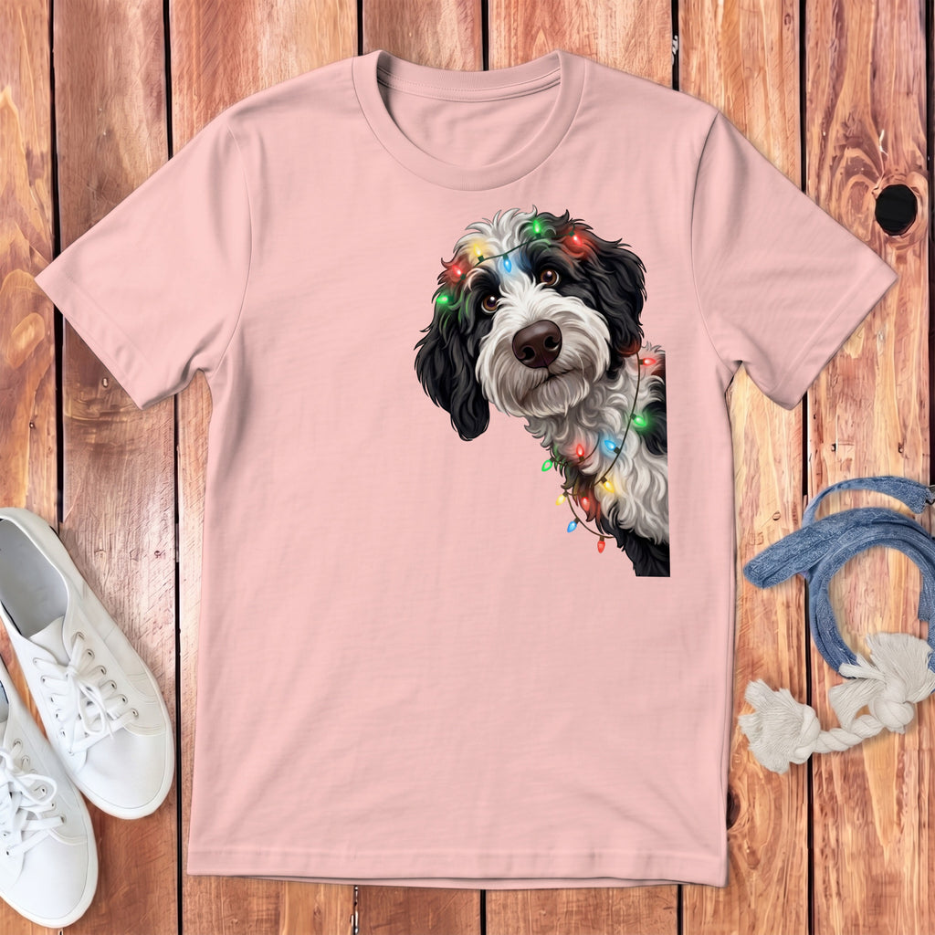 Pink t-shirt with a black and white dog wearing Christmas lights graphic.
