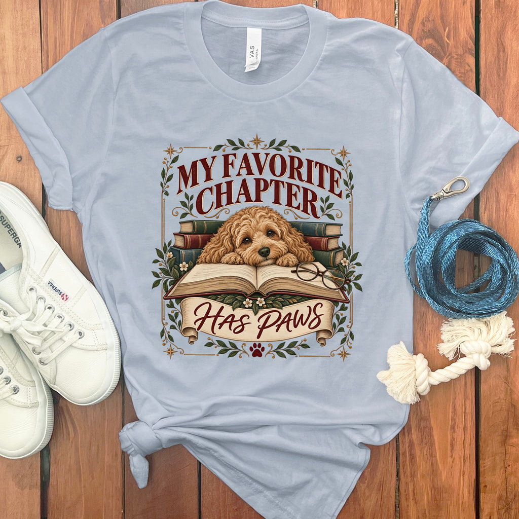 Light blue t-shirt with a dog, books, glasses, and text "MY FAVORITE CHAPTER HAS PAWS".