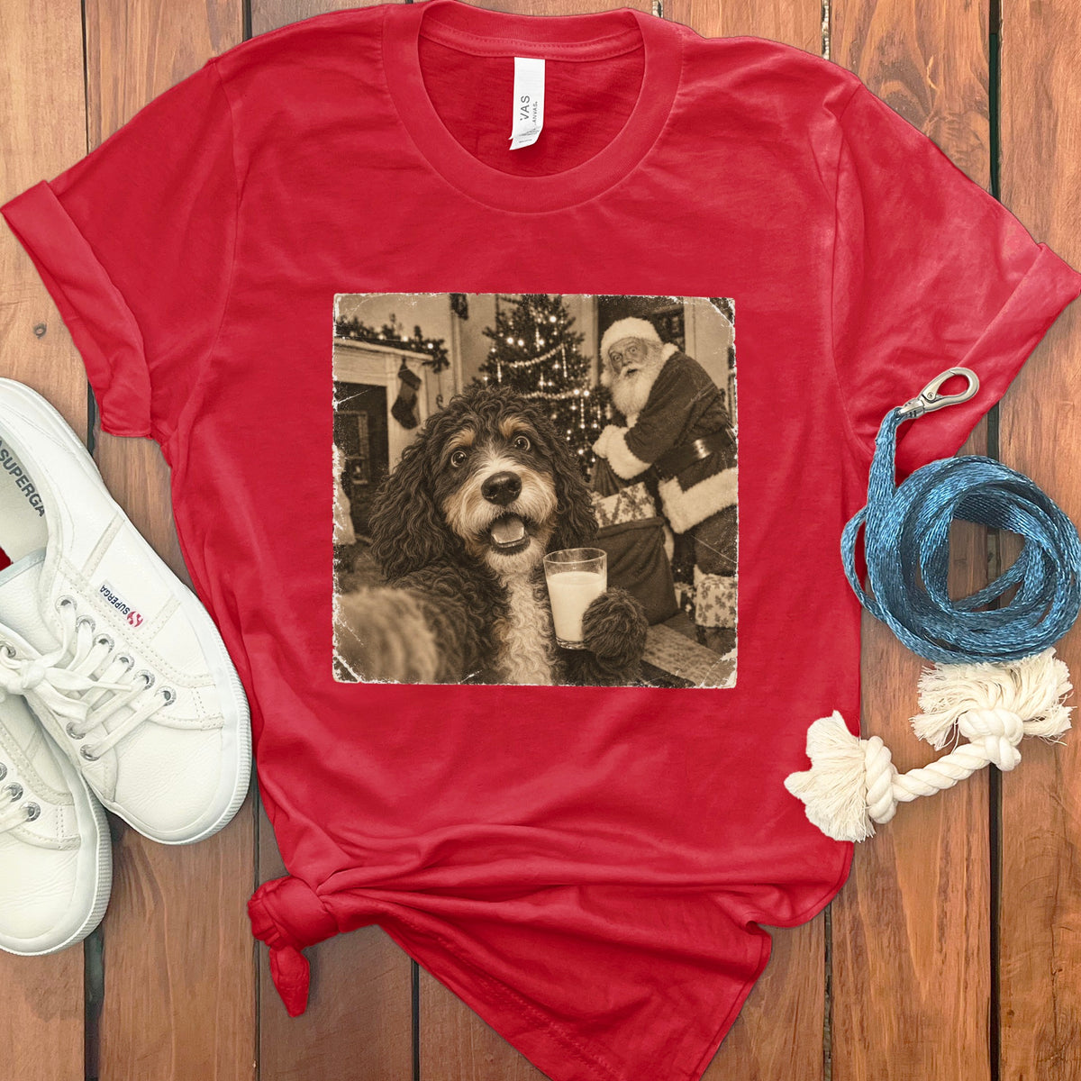 Red crewneck t-shirt featuring a black and white graphic of a dog holding a glass of milk with Santa Claus in the background.