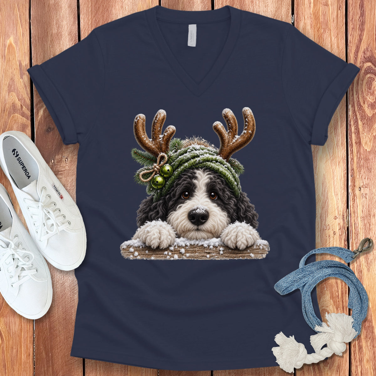 Bernese Mountain Dog wearing reindeer antlers and festive hat, peeking over wood.