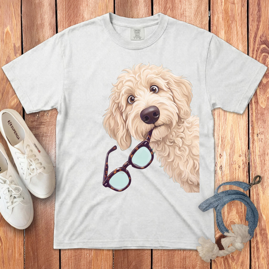 A white crewneck t-shirt featuring an illustration of a fluffy golden doodle holding glasses in its mouth.