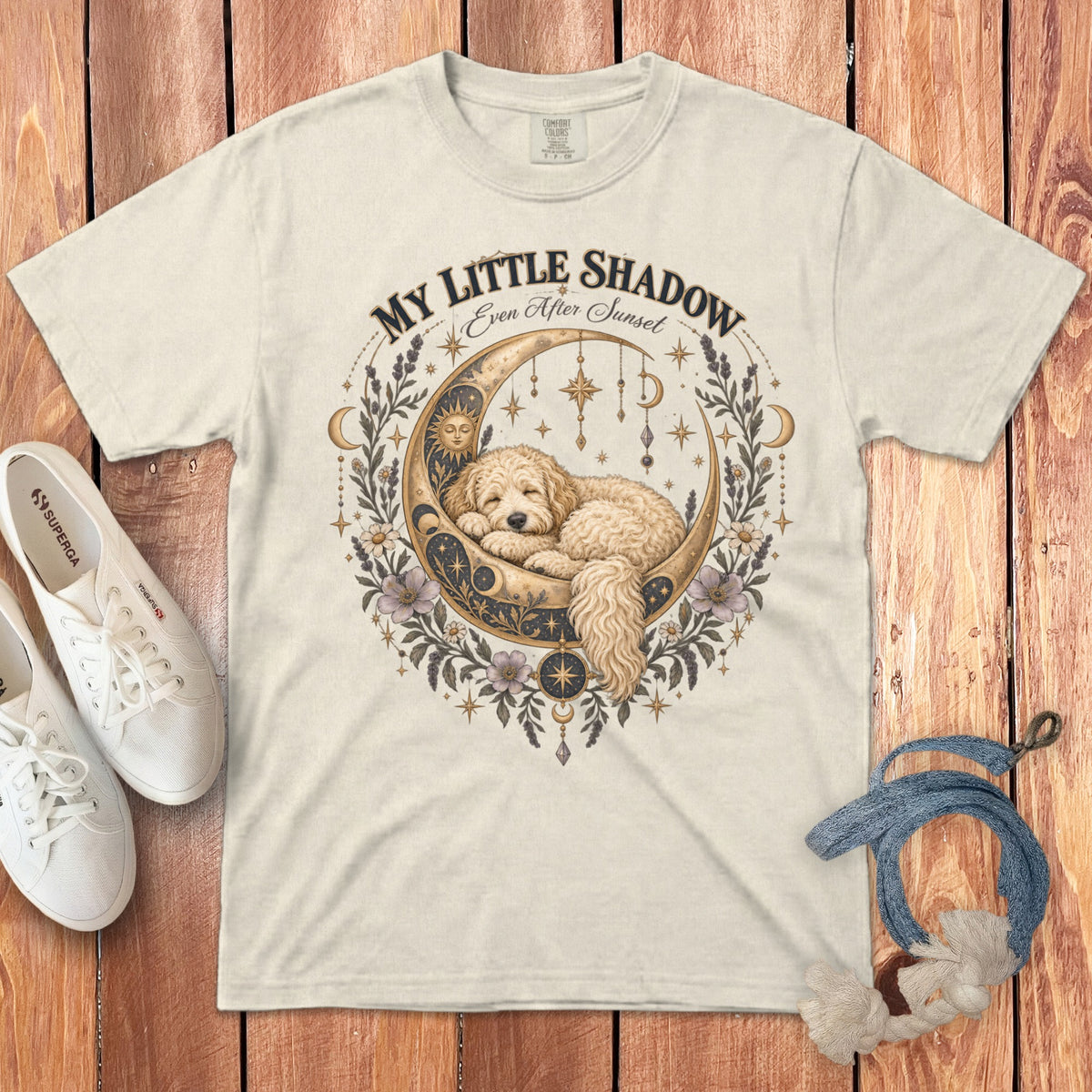 Cream t-shirt with a gold moon, sleeping dog, and floral celestial design.