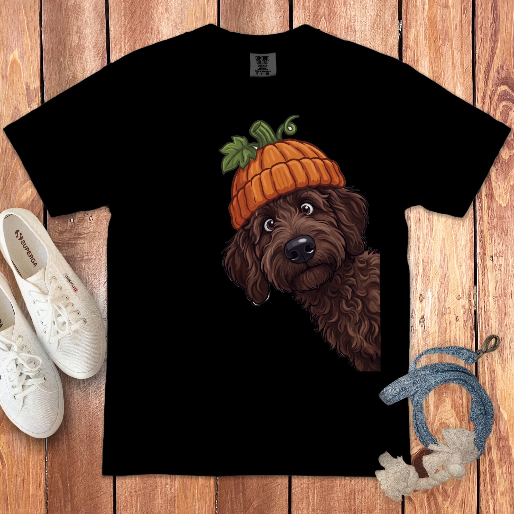 Black t-shirt featuring a brown dog wearing a pumpkin hat, peeking from the side.