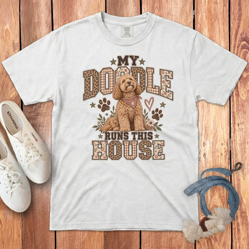 A white t-shirt featuring a graphic of a Goldendoodle and text that reads My Doodle Runs This House.
