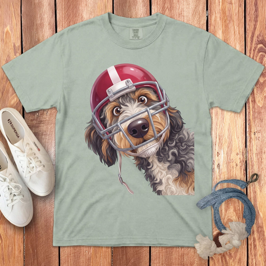 Dog wearing a red and white football helmet on a pale green t-shirt.