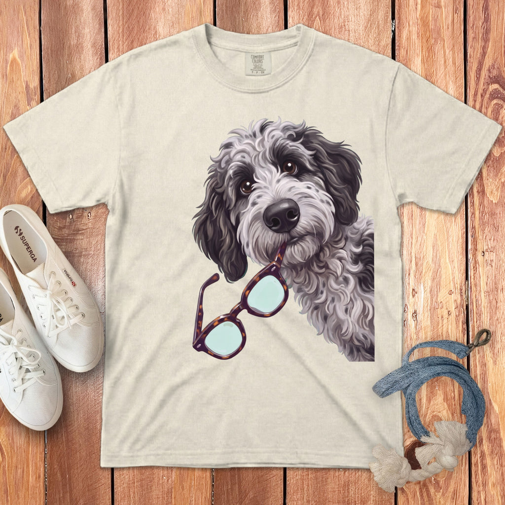 Beige crewneck t-shirt featuring an illustration of a fluffy grey dog holding glasses in its mouth.