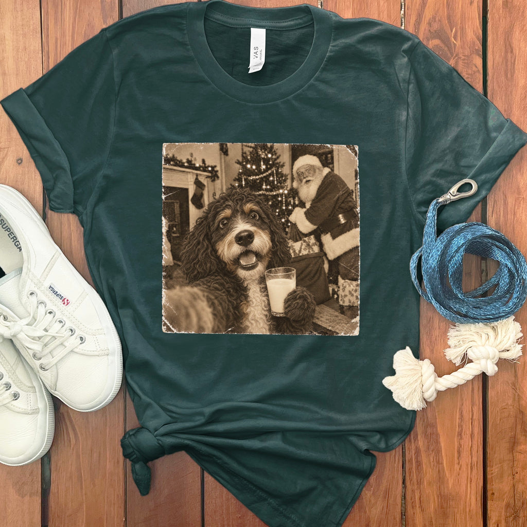 Dark green crewneck t-shirt with a vintage graphic of a doodle dog holding a glass of milk in front of Santa Claus.