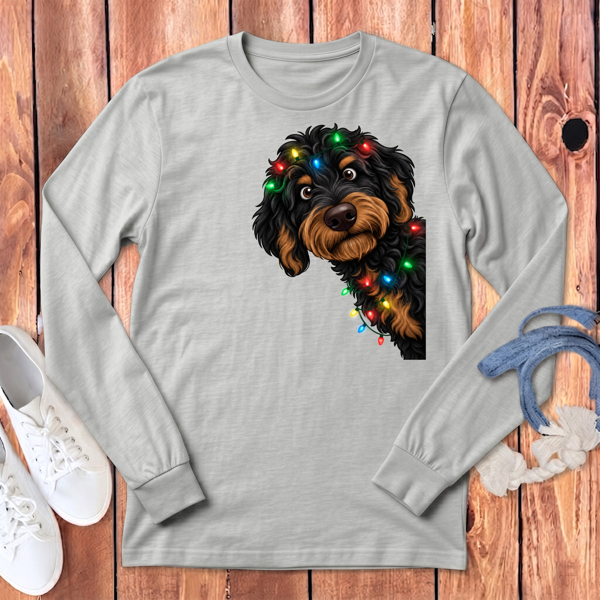 Gray long-sleeve shirt with a black and brown dog wearing colorful Christmas lights.