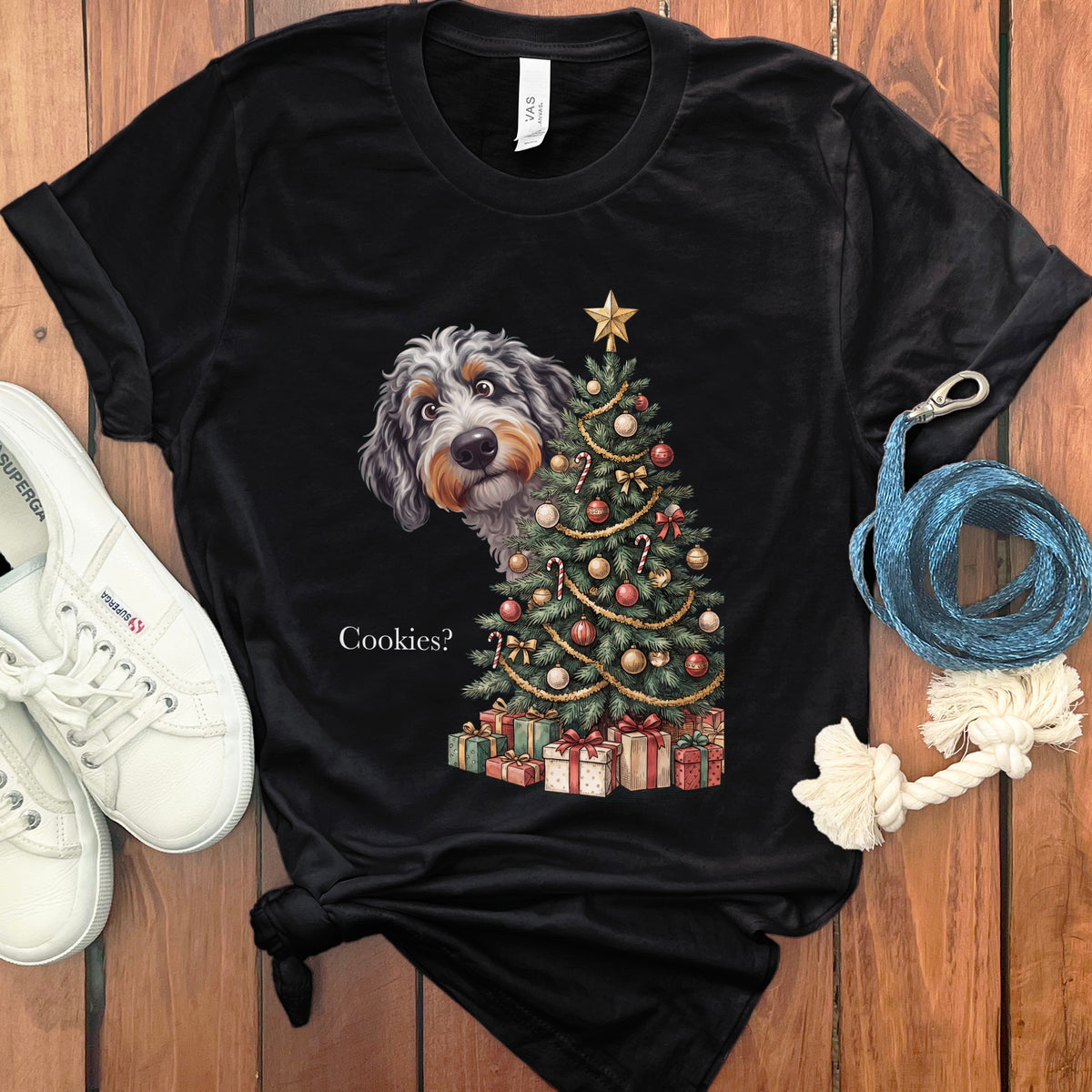 Black t-shirt featuring a dog peeking from behind a decorated Christmas tree with presents.