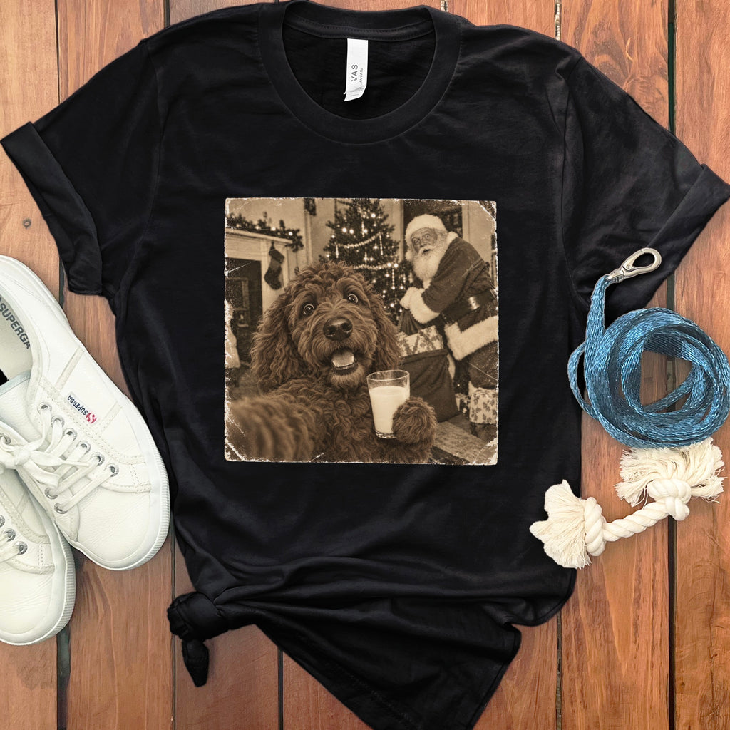 Black crewneck t-shirt with a vintage graphic of a curly brown dog holding a glass of milk with Santa Claus in the background.