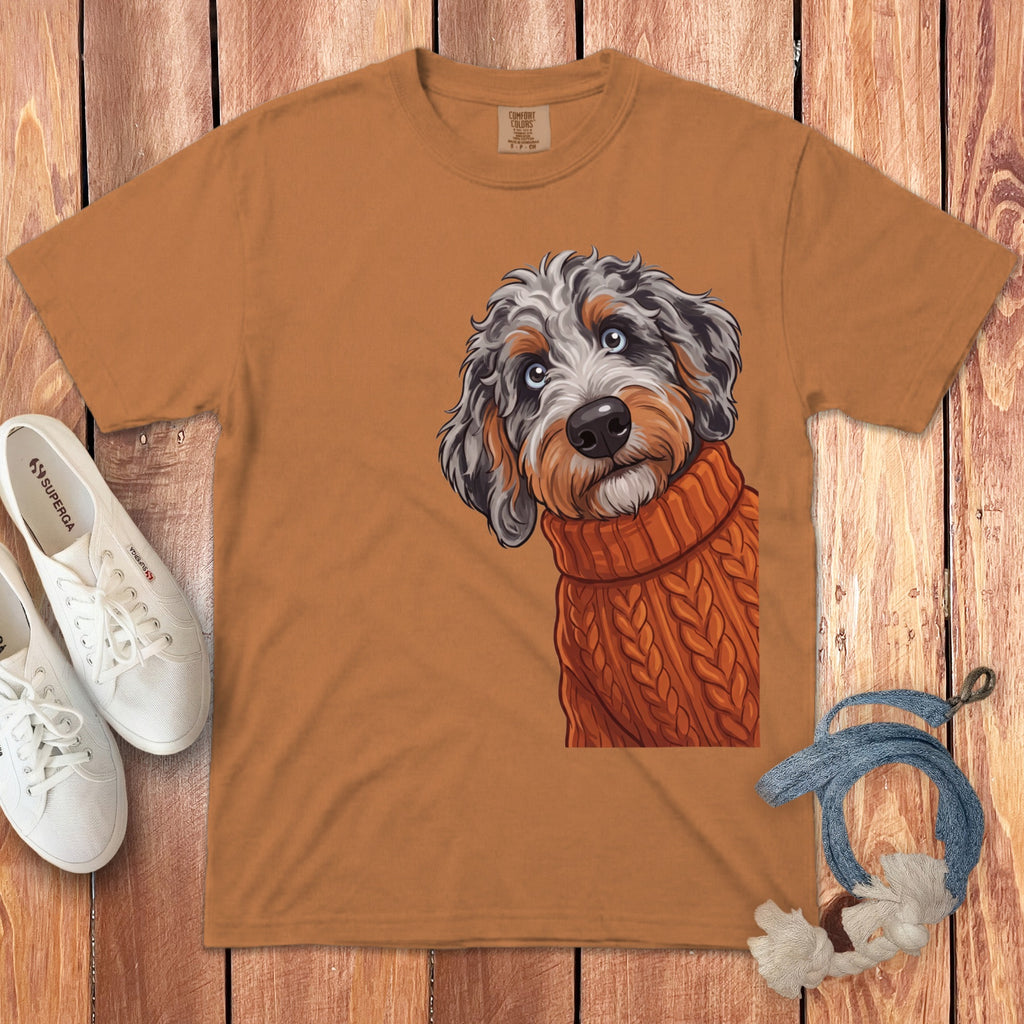Orange t-shirt graphic of a doodle dog wearing a knitted sweater.