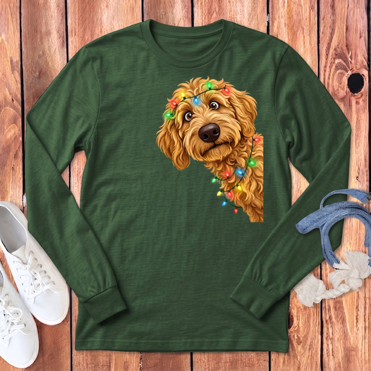 Green long-sleeve shirt with a goldendoodle peeking from the side, wearing Christmas lights.