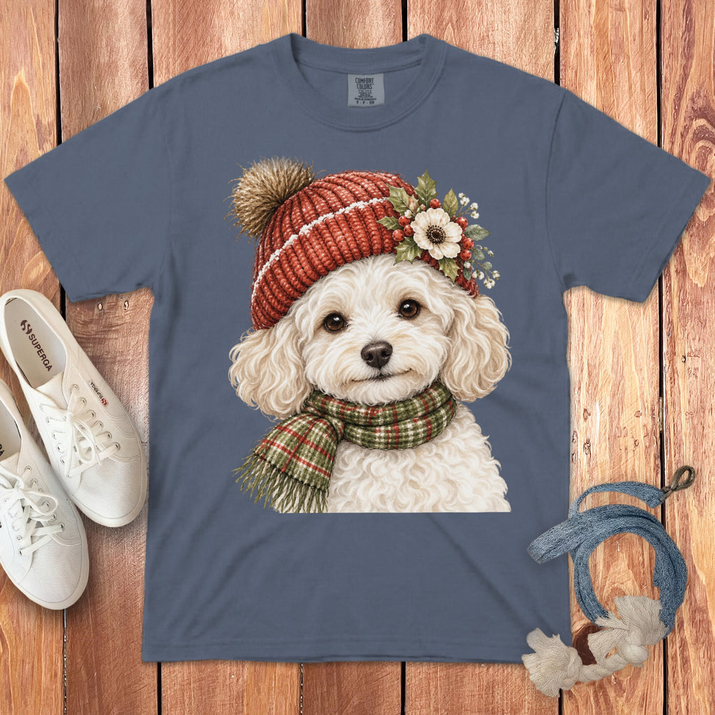 Fluffy white dog wearing a red knitted hat and green plaid scarf.