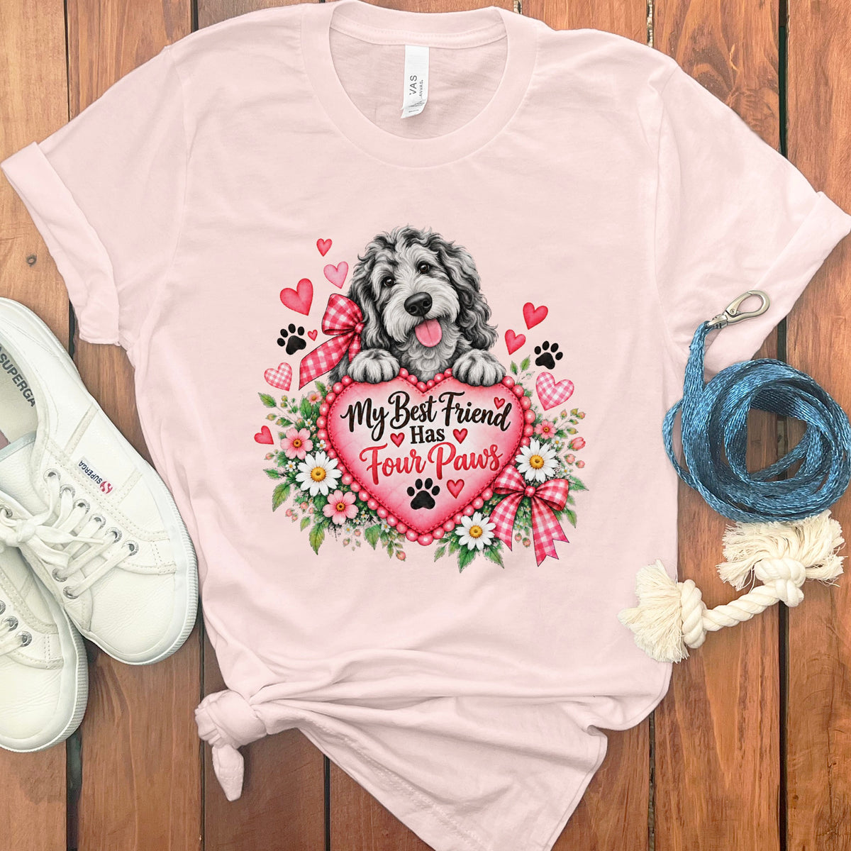 Light pink t-shirt featuring a doodle dog resting on a heart with the text My Best Friend Has Four Paws.