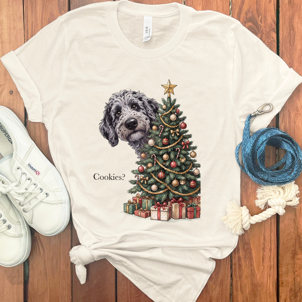 Dog peeking behind a Christmas tree with gifts and the text "Cookies?"