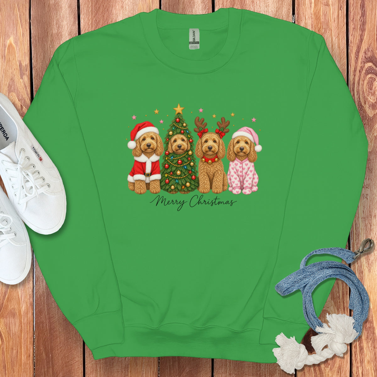 A green crewneck sweatshirt featuring a graphic of four doodle dogs, a Christmas tree, and Merry Christmas text.