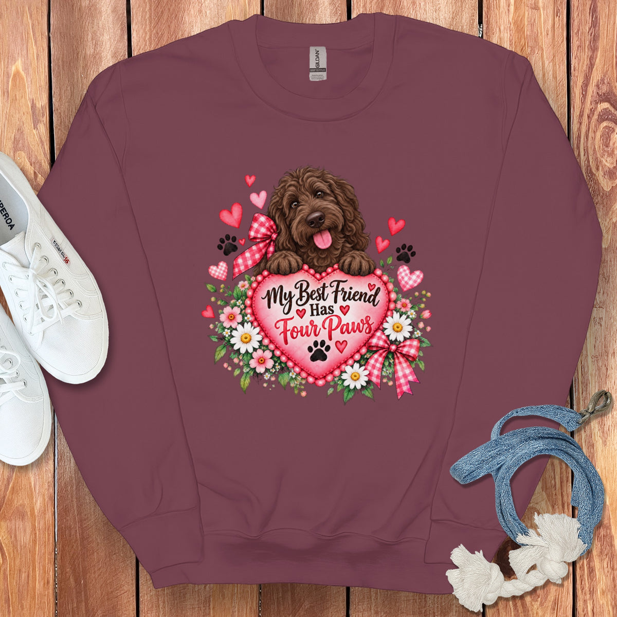 A maroon crewneck sweatshirt with a graphic of a brown dog, flowers, and the text My Best Friend Has Four Paws.
