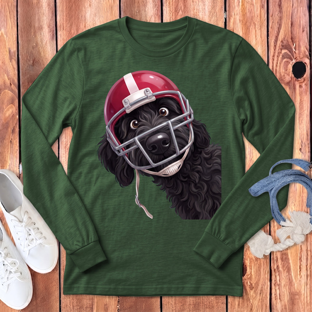 Black dog wearing a red football helmet and facemask on a green long-sleeve shirt.